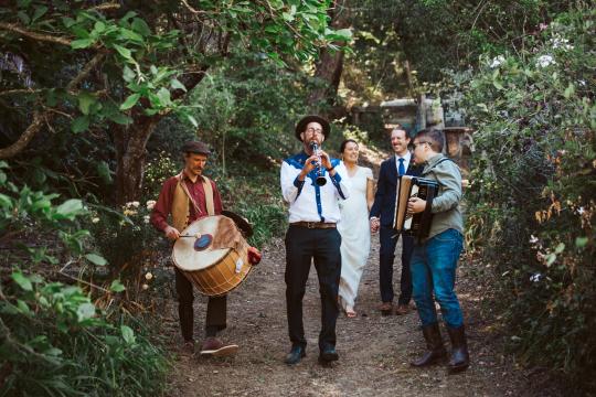people playin instruments and walking through a forest