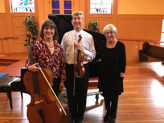 Cellist, violinist, and pianist standing next to each other