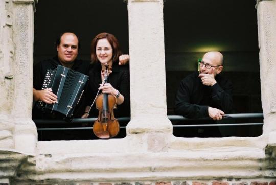 Veretski Pass members with instruments standing by a window